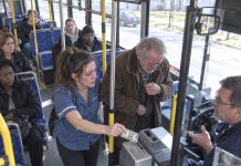 She almost walked past the elderly man because she was already late getting home, but something made her turn around and quietly pay his fare. The next day, flashing police lights stopped outside her house, and when she opened the door, an officer said something she never expected to hear.