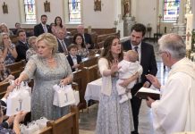 My mother had controlled my birthdays, my wedding, and nearly every important decision in my life. But I never imagined she’d try to take control of my son’s identity, too. During his baptism, she interrupted the ceremony and loudly declared, “The name you chose is embarrassing! I’ve already told everyone his REAL name!” Then she began distributing expensive gifts engraved with the name SHE wanted, while my relatives nodded and smiled. My husband went completely still beside me. I could feel my mother’s eyes on us, daring me to embarrass her in front of the entire church. So I walked straight toward the priest, holding my son against my chest, and asked him to stop the ceremony. What happened next was something my mother never expected…