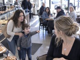 My five-year-old son pointed at a woman in the bakery and whispered, “Mommy, she comes to our house when you’re working. She plays in your bedroom.” After ten years of marriage, I felt my entire world collapse. I walked toward her, ready to confront my husband’s mistress. Then I saw her necklace. I recognized it immediately—and suddenly, everything was far worse than I imagined.