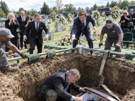 “Hurry up!” my son shouted as the gravediggers lowered his mother into the ground, but then the cable snapped without warning. I pushed past everyone, jumped into the grave, and stared inside the open coffin—and suddenly the funeral became the beginning of something far more disturbing.