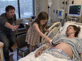 Doctors had almost stopped expecting Emily to wake before giving birth. But on one rainy afternoon, a seven-year-old girl quietly entered her room, spread dark soil across her pregnant belly, and whispered something no one else could hear. Emily’s husband was about to stop her—until he saw his wife’s hand twitch.
