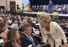“Move! That seat belongs to me!” my son’s stepmother snapped at his graduation. My ex just watched as I stood alone by the exit. Minutes later, my son pointed straight at her from the stage… and the entire auditorium went silent.
