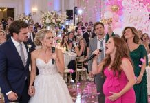 At my own wedding, my sister stole the spotlight with a gender reveal and announced, “Surprise! Mom gave us your honeymoon tickets as our baby gift!” My family erupted in cheers, expecting me to smile and accept it. Instead, I raised my glass and said, “Congratulations! Now let me tell everyone what Mom and my sister don’t want you to know…” Within seconds, all 99 wedding guests stopped smiling.