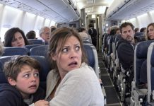 My husband had been dead for four years. During a flight home, my son suddenly grabbed my arm, trembling. “Mom… Dad is sitting two rows behind us.” My heart nearly stopped. I slowly turned around, praying he was mistaken. But what I saw left me completely frozen…