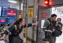 The chemical alarm screamed. My dosimeter was red, hers was amber. He gave her the last antidote, then carried her out—leaving me at the controls as the steel door sealed between us.